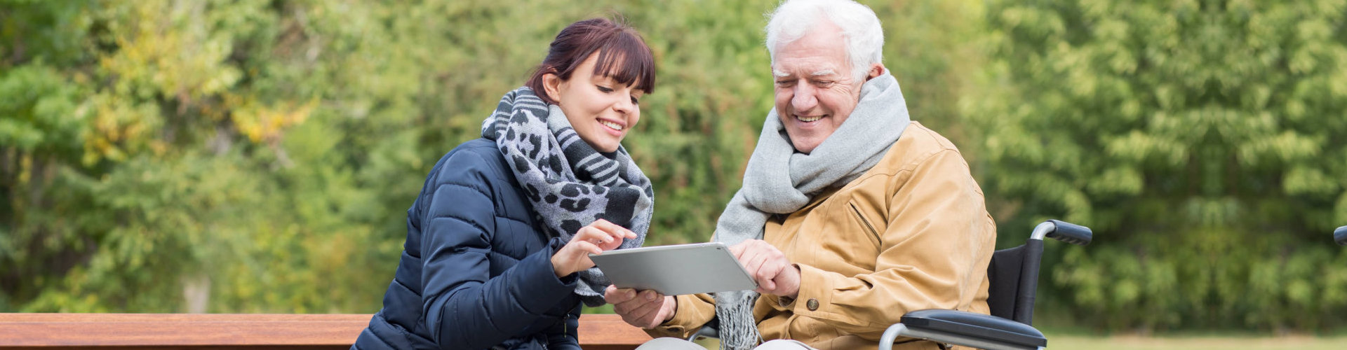 caregiver teaching elderly how to use the ipad